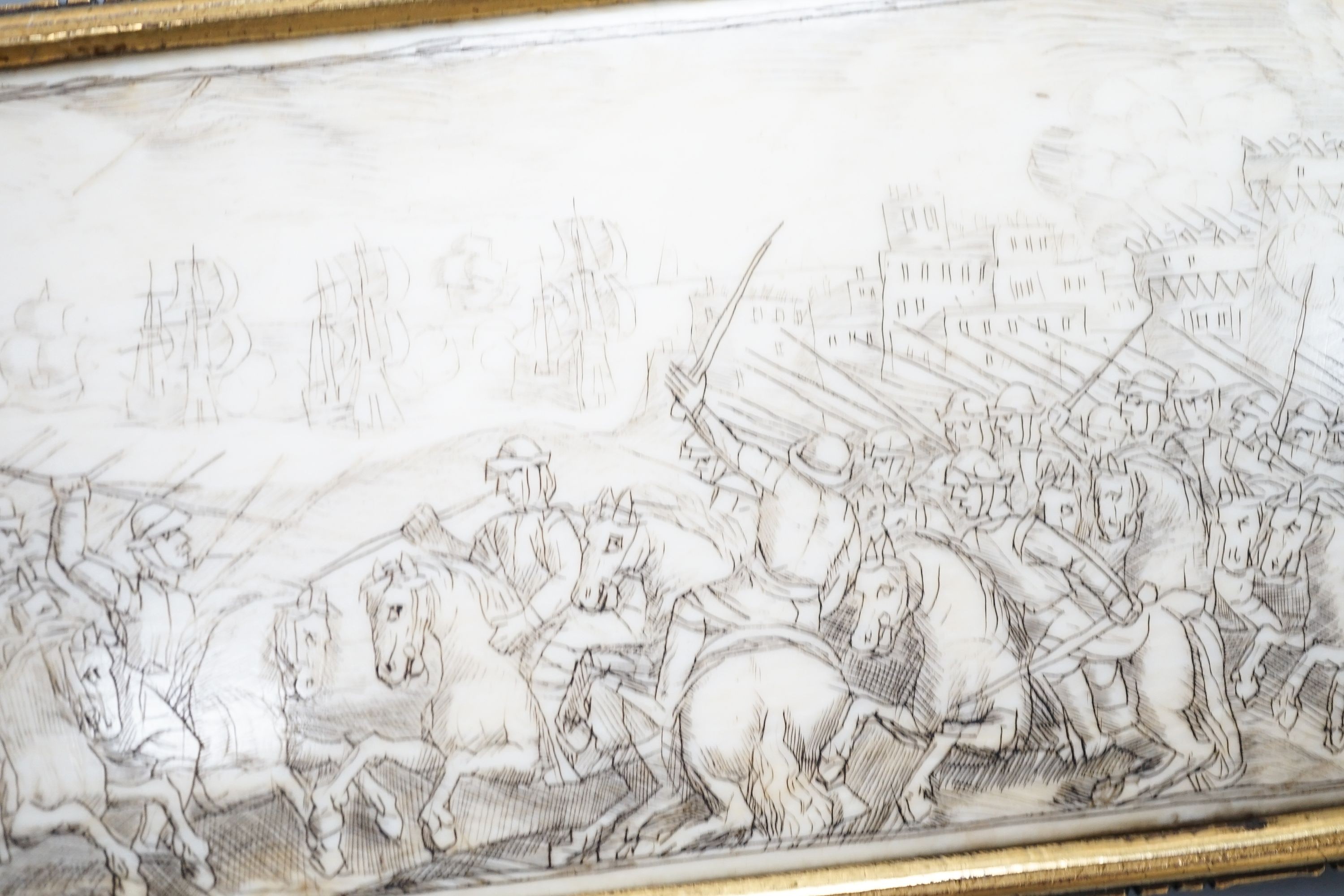 A 17th century French oval ivory plaque in a revolving metal surround, etched on both sides with battle scenes and ships in the background 17cm
